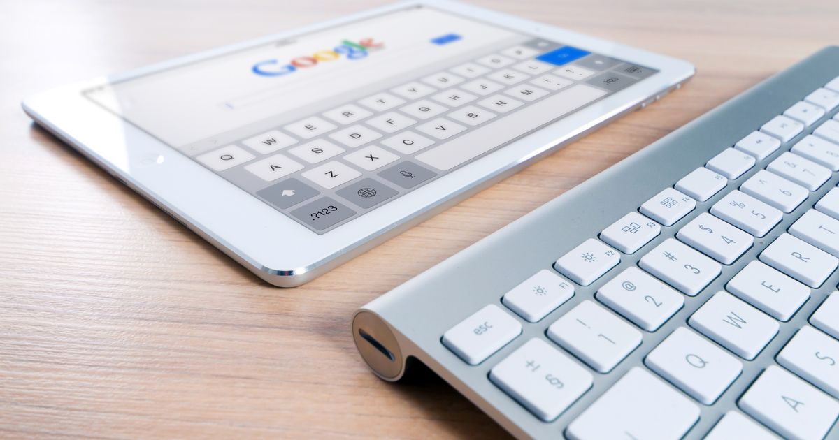 Tablet com a busca do Google aberta ao lado de um teclado sem fio