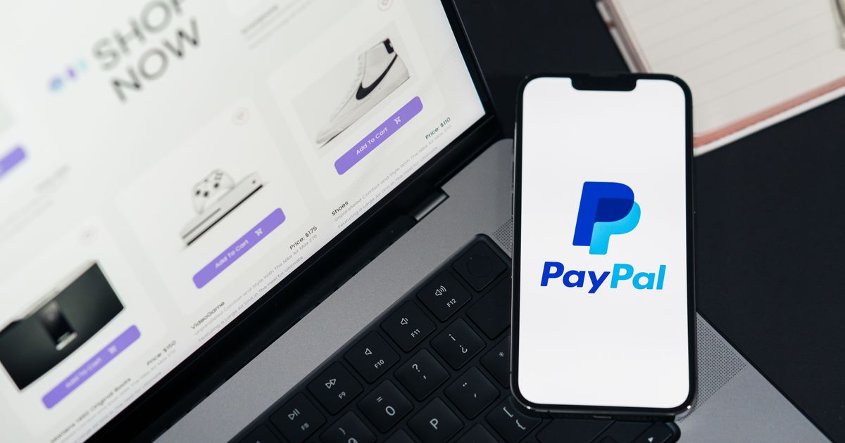 Celular exibindo aplicativo de pagamento ao lado de notebook com loja virtual aberta