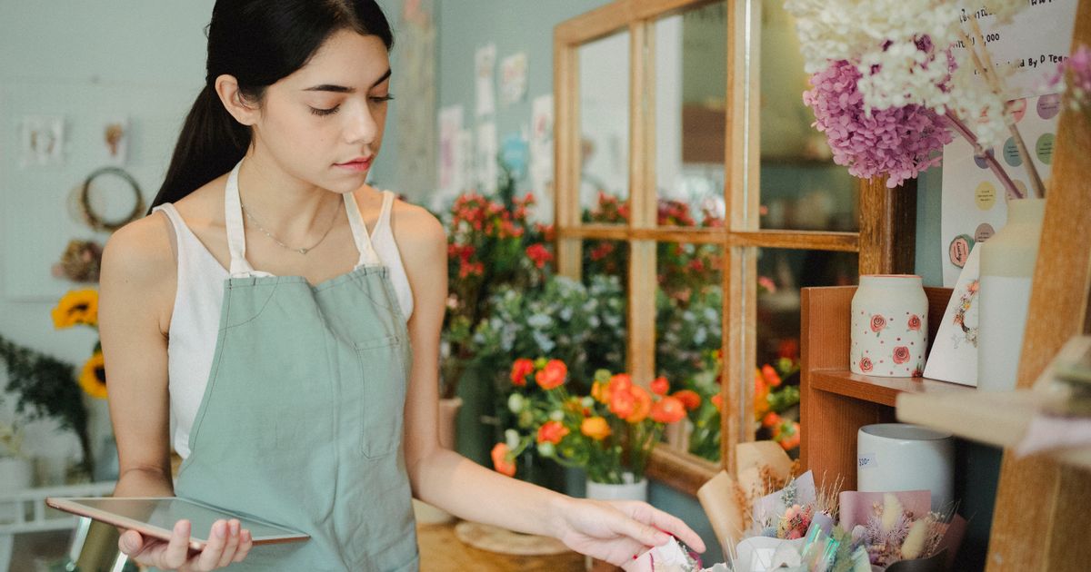 Florista organizando arranjos na própria loja de flores